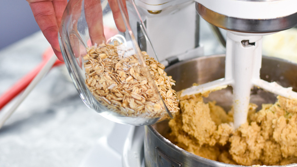 bowl of quick oats being poured into the stand mixer's bowl