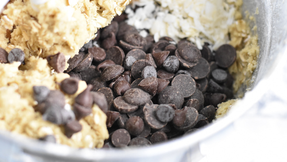 chocolate chips, coconut flakes and chopped walnuts in the batter in the mixing bowl