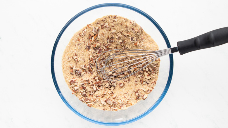 Chopped pecans, sugar, and flour in mixing bowl