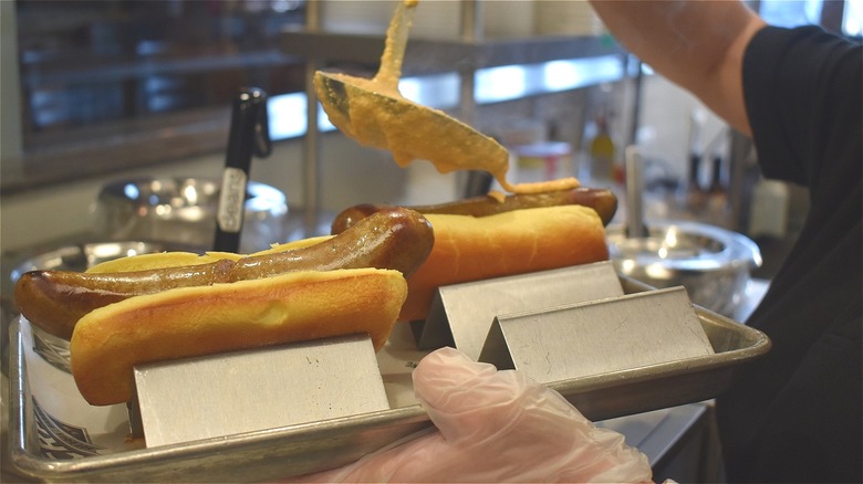 employee preparing hot dogs