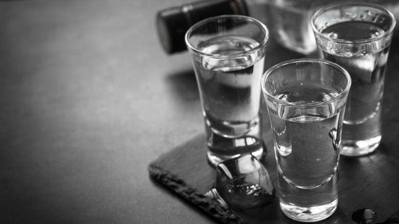 three shot glasses filled with clear liquid