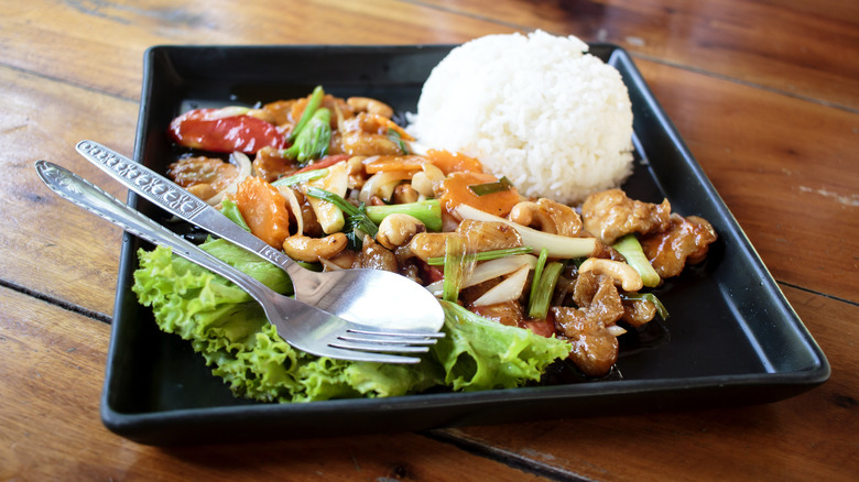 fork and knife with stir fry and rice