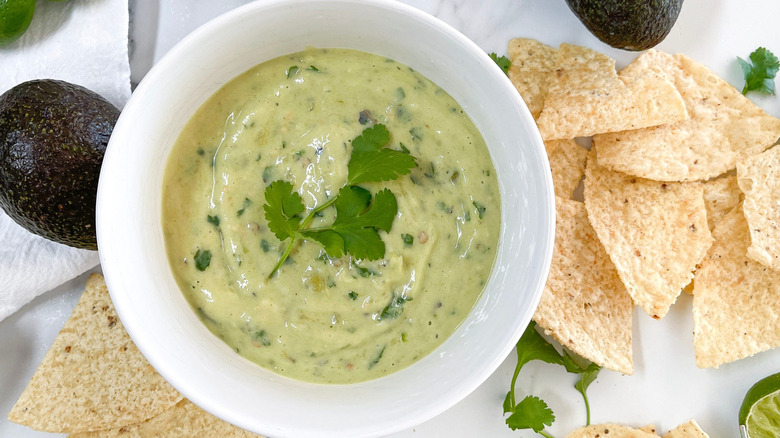 Salsa verde with cilantro next to tortilla chips