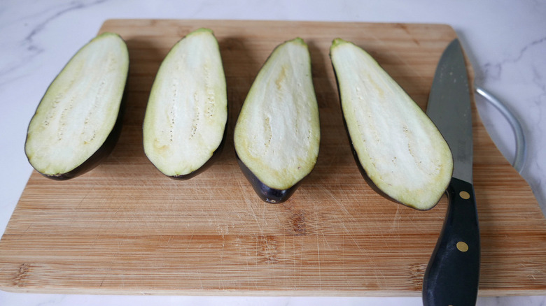 halved eggplants on cutting board