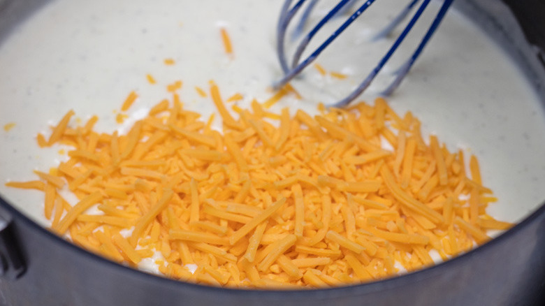 whisking cheese into sauce