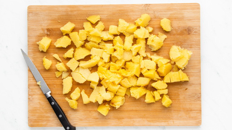 chopped cooked potato on cutting board