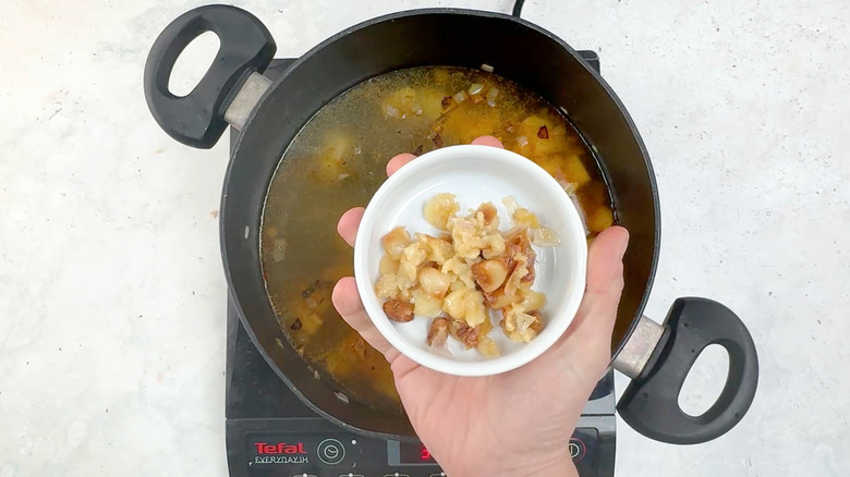 adding roasted garlic to soup