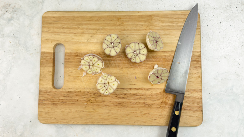 chopped garlic heads on wooden board