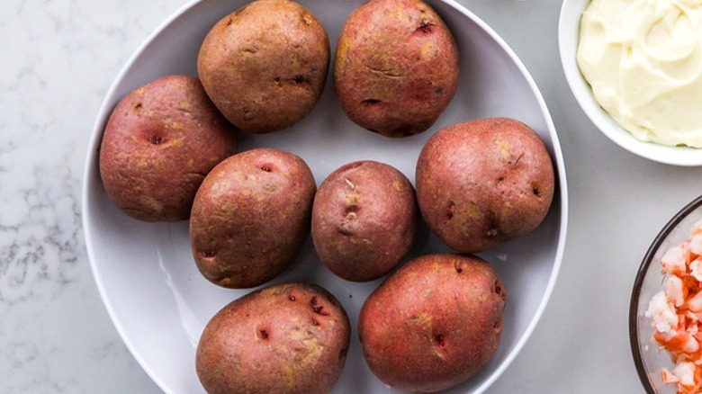 raw potatoes in white bowl