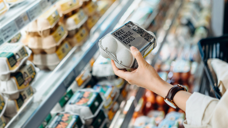 person buying eggs in grocery store