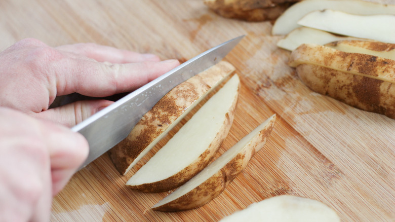 Slicing the potato into wedges