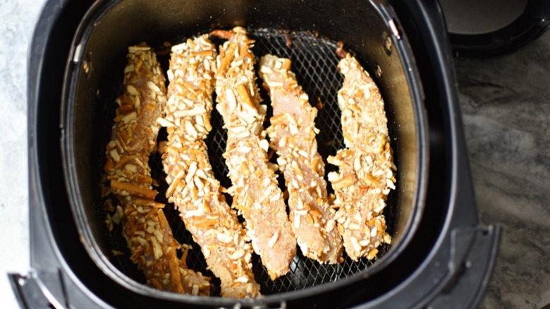 pretzel-coated chicken strips in an air fryer