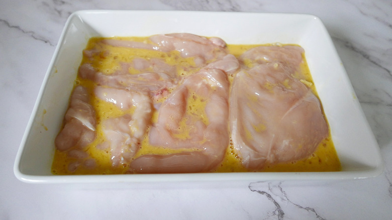 chicken pieces in an egg mixture