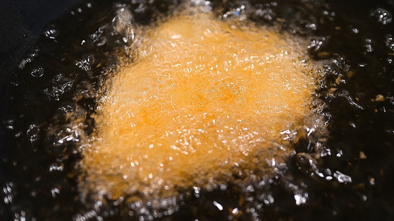 breaded pork cutlet frying in oil