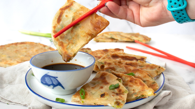 scallion pancake dipping into sauce