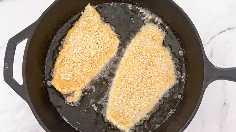 catfish frying in cast iron pan