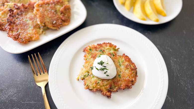 Zucchini fritter on a plate with sour cream