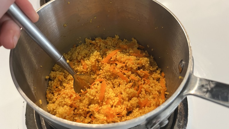 hand poking fork into couscous