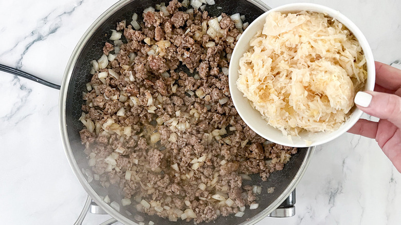 adding sauerkraut to meat mixture