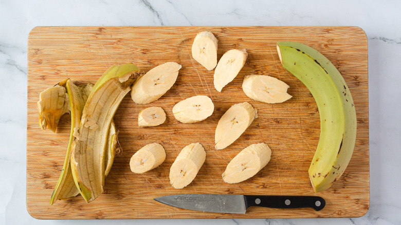 plantains on cutting board with knife