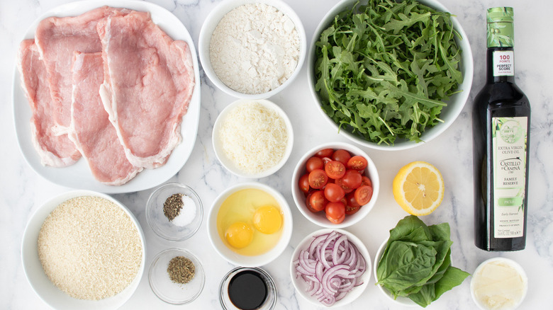 raw veal cutlets with produce, grated cheese, raw eggs, oil, and seasonings