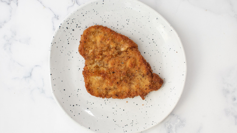 fried breaded cutlet on a white plate