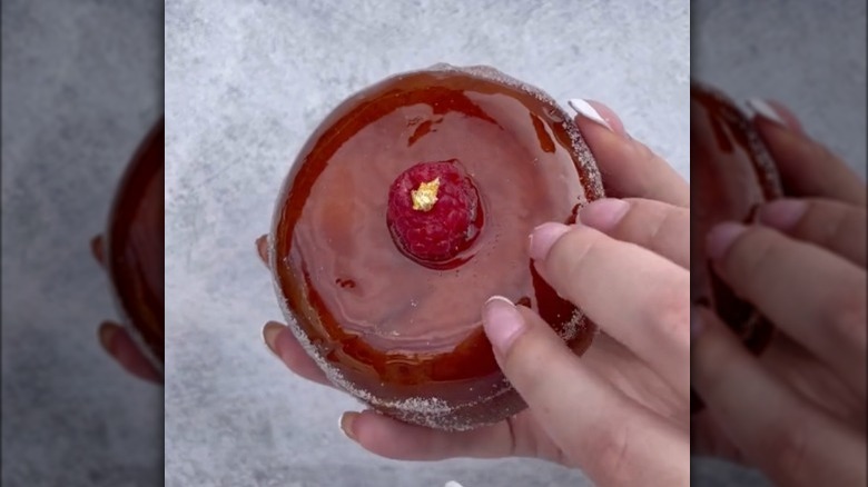 Fingers tapping on a creme brûlée donut 