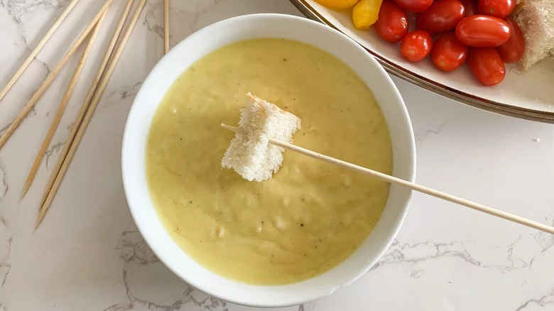 bread dipped in bowl cheese fondue