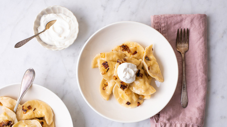 plate of pierogi with sour cream