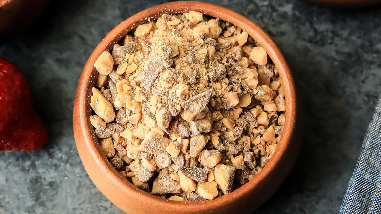 brown bowl filled with toffee bits on marble tabletop