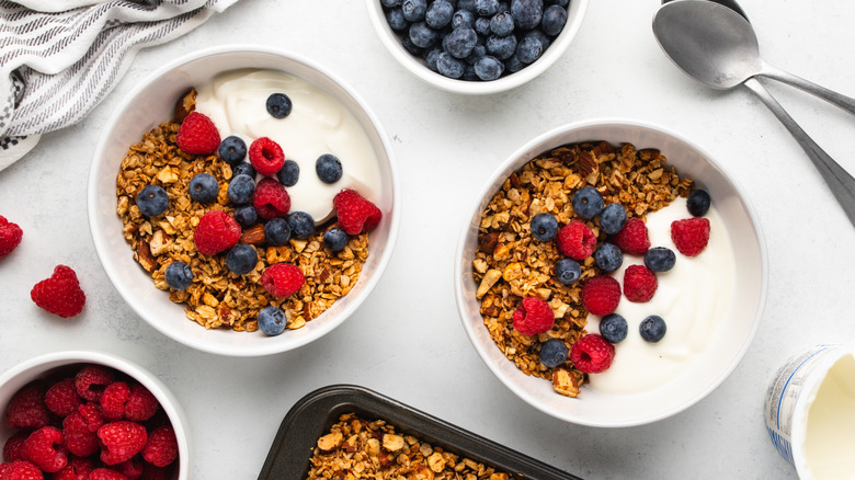 Two bowls of granola with yogurt and berries