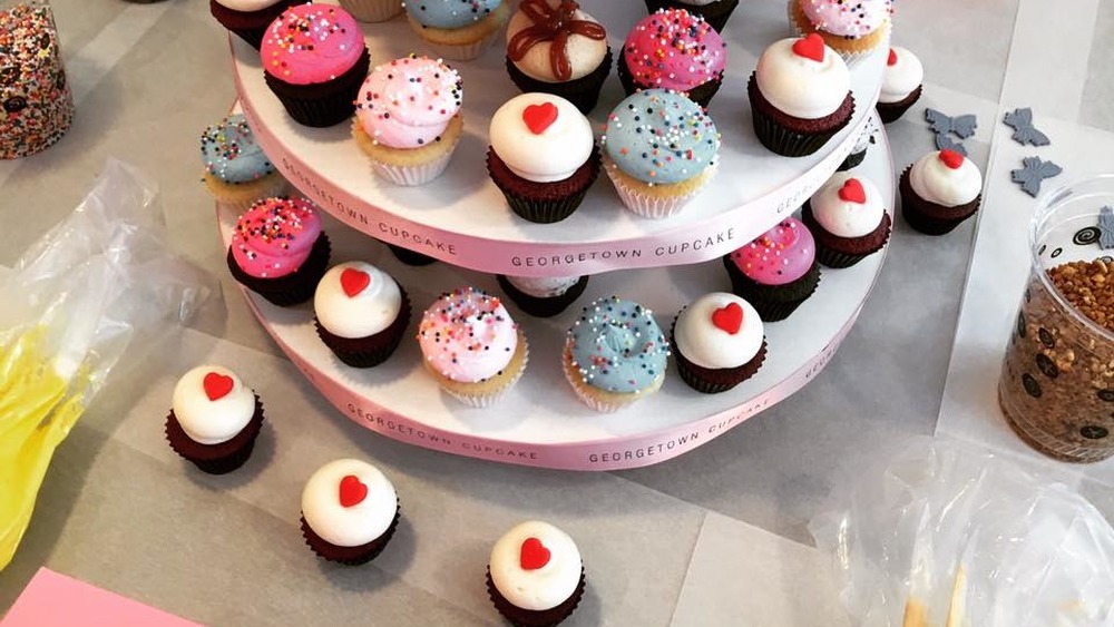 tiered trays full of cupcakes on a table