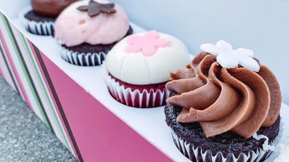 row of cupcakes in a pink cardboard box