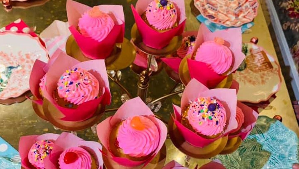 table full of pink frosted cupcakes