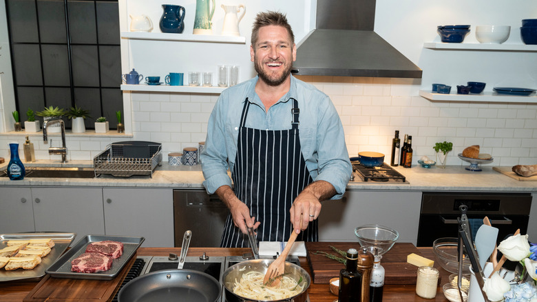 Curtis Stone cooking in a kitchen