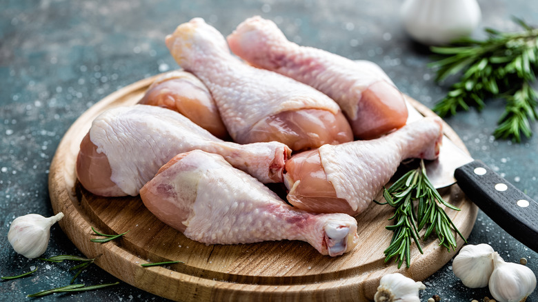 raw chicken drumsticks on a plate