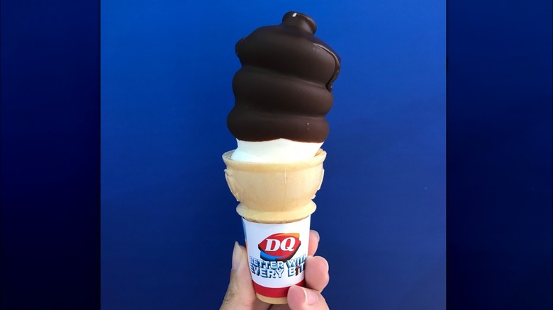 Hand holding Dairy Queen chocolate dipped cone