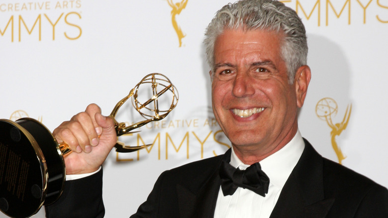 Anthony Bourdain holding Emmy Award