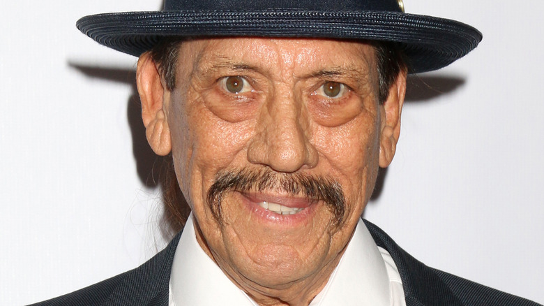 Danny Trejo with slight smile and wide-brimmed hat