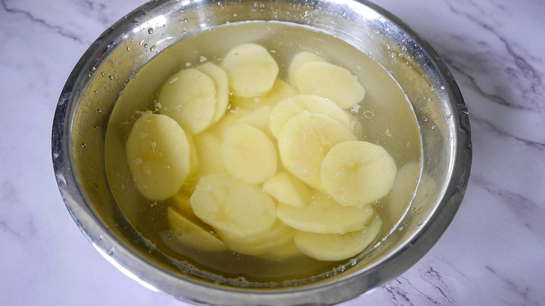 sliced potatoes soaking in water