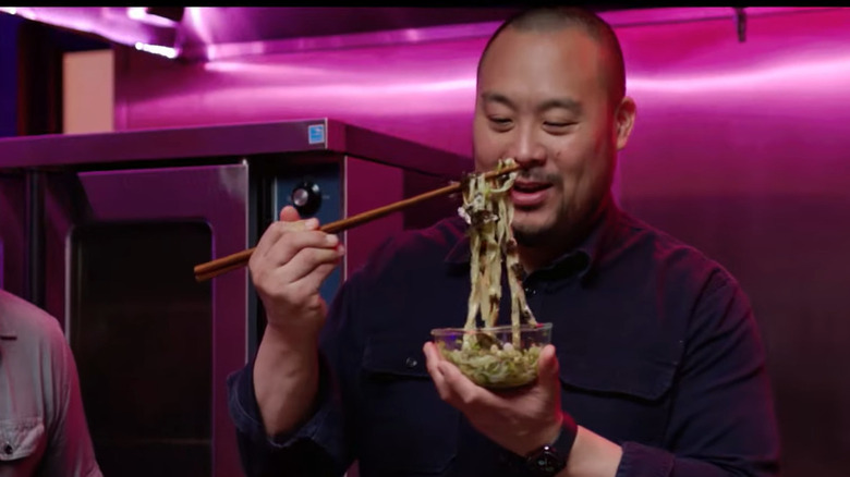 David Chang holding noodles