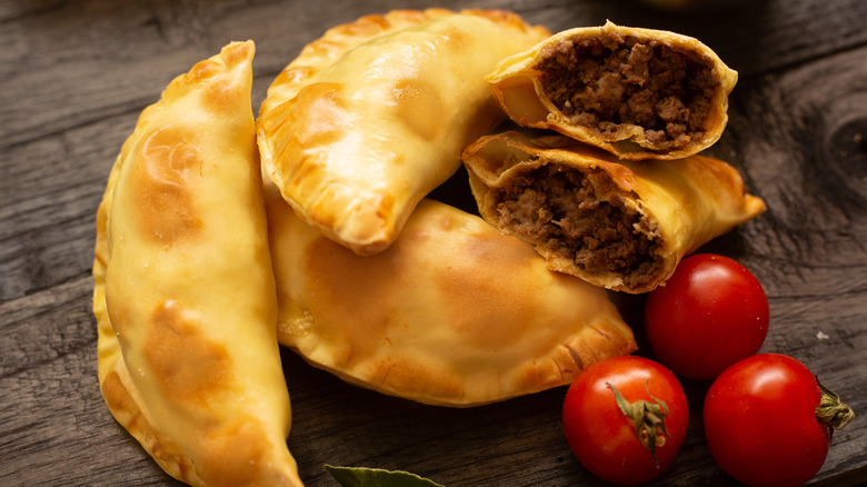 pile of empanadas with little tomatoes