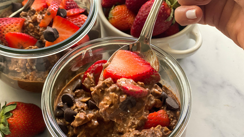 hand with spoon scooping oatmeal