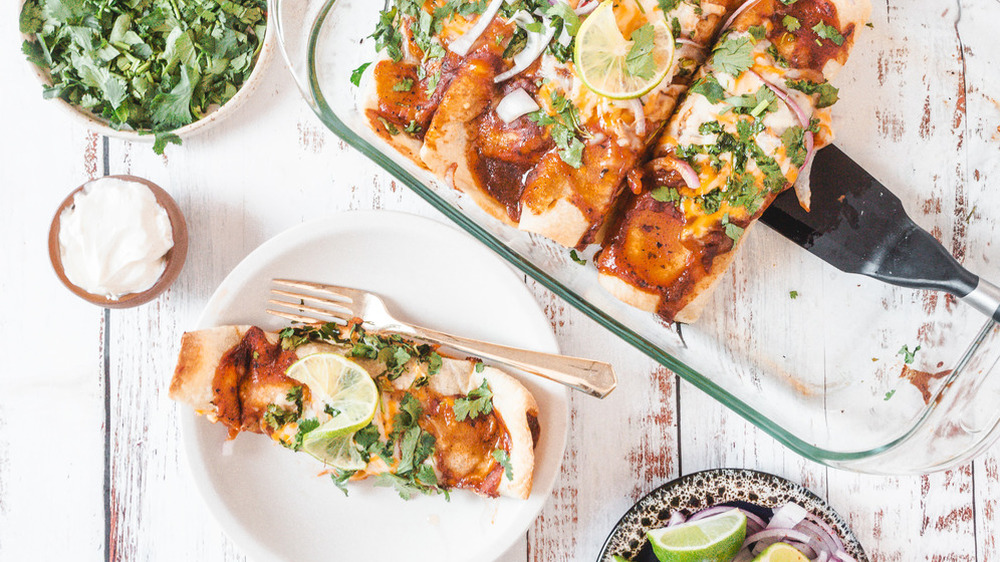 chicken enchiladas in a glass baking pan with cilantro 