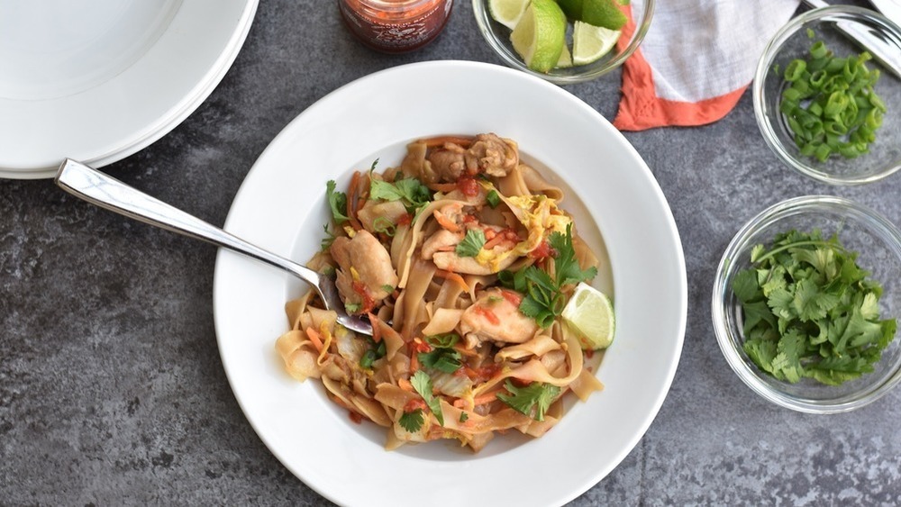 Drunken noodles in white bowl on gray surface