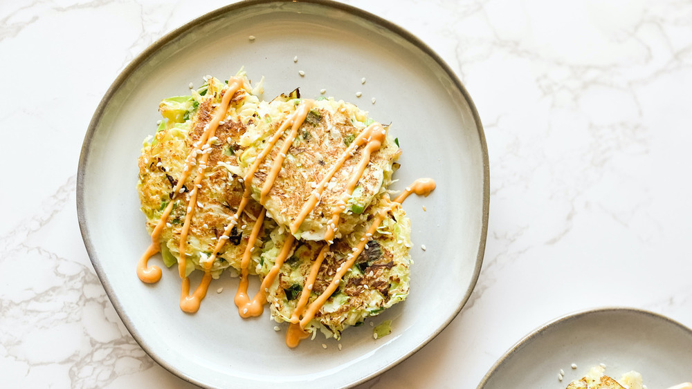 Okonomiyaki on white plate with Sriracha mayonnaise dressing