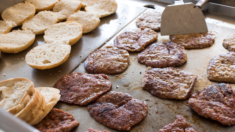 Burger patties and buns on flat grill