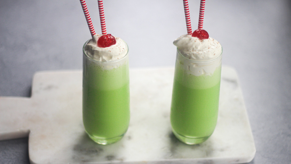 Green milkshakes in glasses with straws