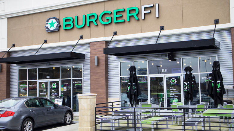 A BurgerFi location with seating and umbrellas