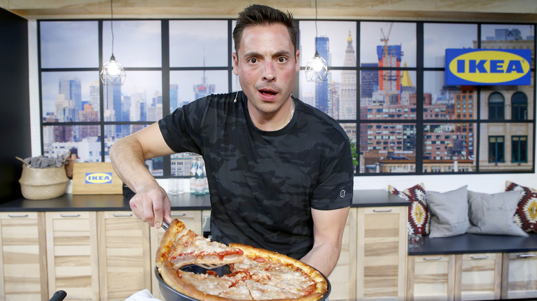 Jeff Mauro holding a pizza